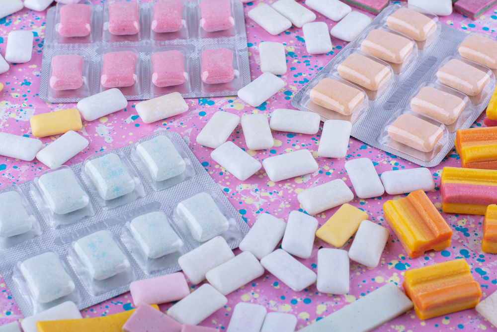 gum tablet packs amid scattered bubblegum pieces colorful surface